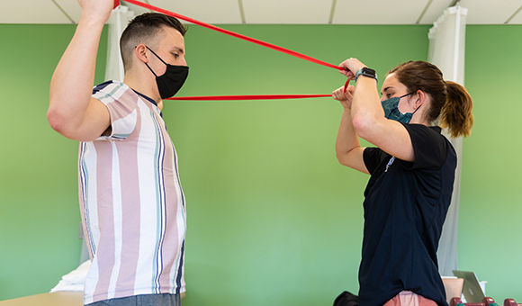 Noah Felix of North Lawrence and Katlynn Allen of Malone work on dynamic resistance exercises during a Physical Therapist Assistant program laboratory.