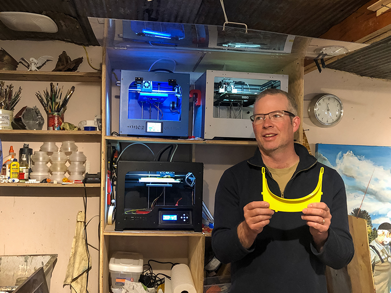 Professor Matthew Burnett holds a 3D printed visor, printed to assist in the COVID-19 battle.