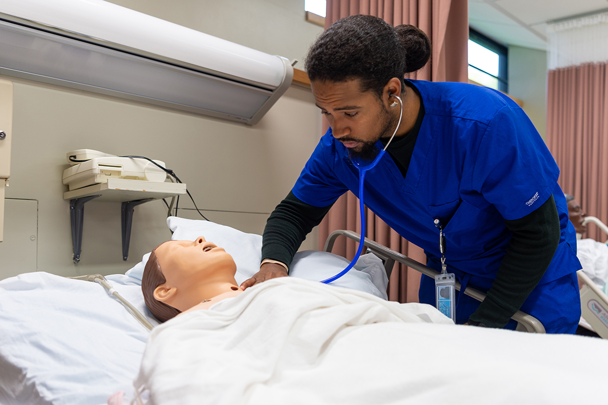 Marcos Martinez tends to a dummy patient in the Nursing lab.