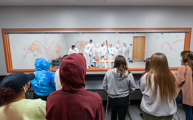 Students view a blood splatter experiment from the observation room.
