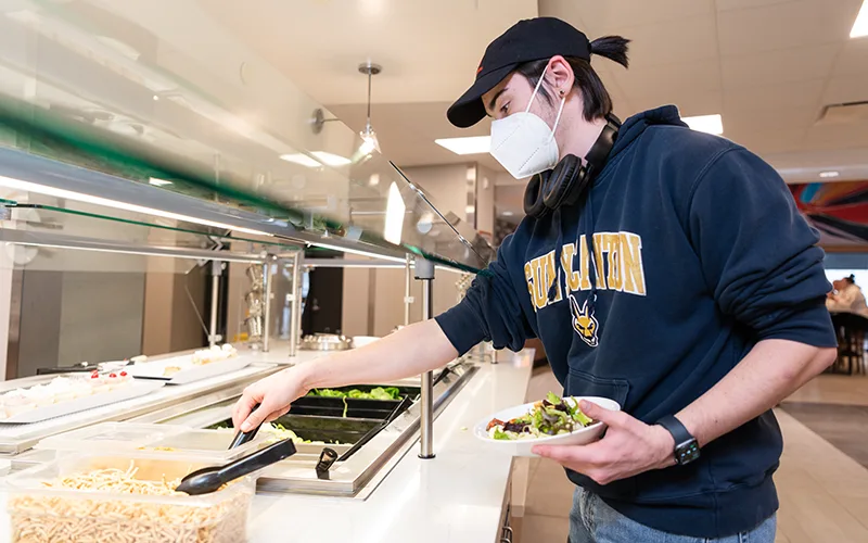 A student selects food from the salad bar in Chaney Dining Center.
