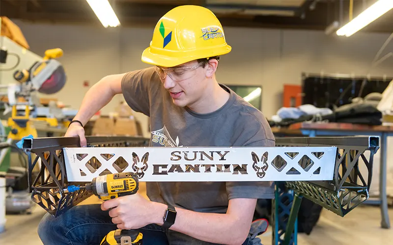 A student drills a bolt on the 2022 steel bridge.