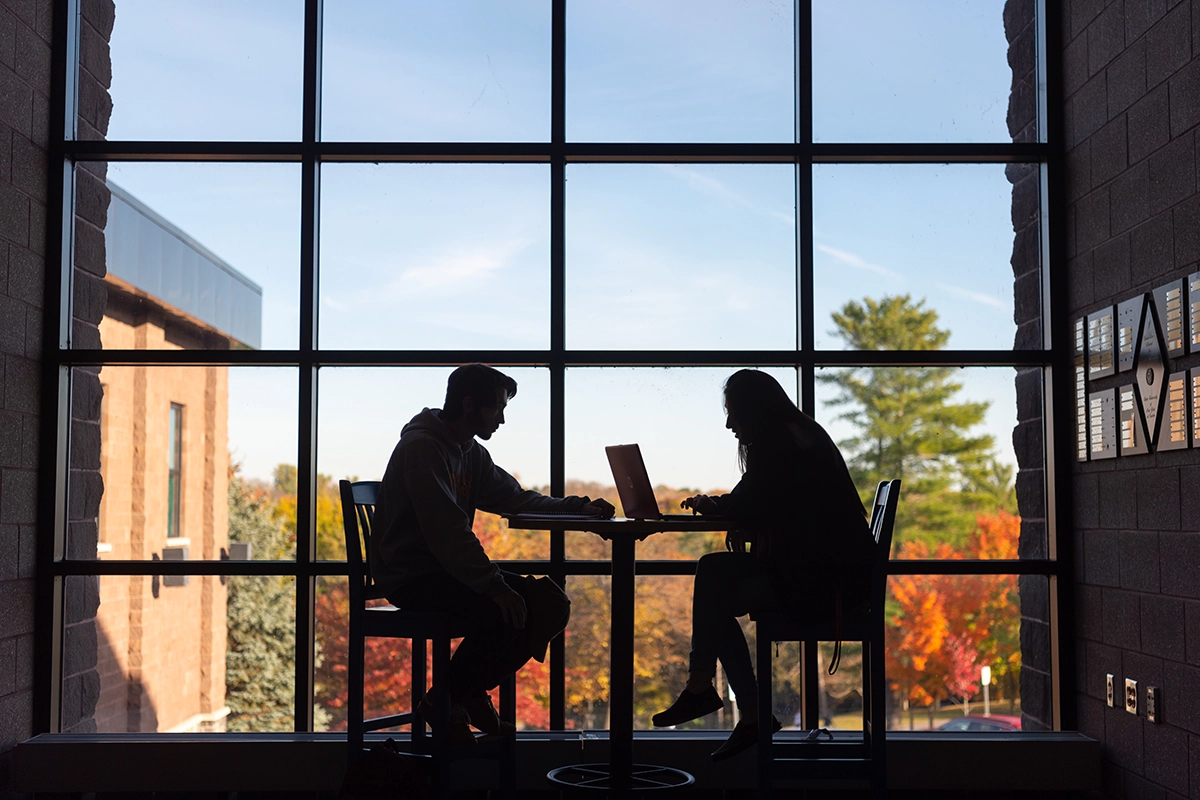 Students sit in the campus center on a fall day.
