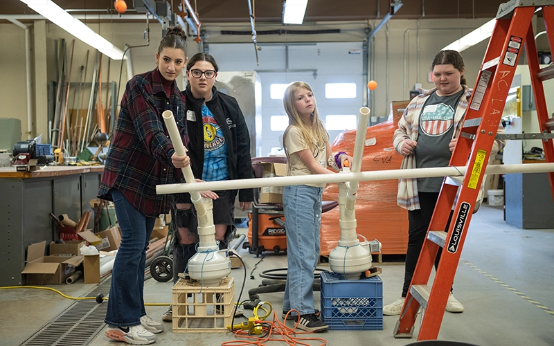 Students launch orange balls at Women in Engineering Day.