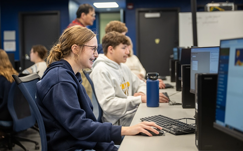 Students in the Early College Dual Enrollment program work in the Cybersecurity lab as part of a visit.
