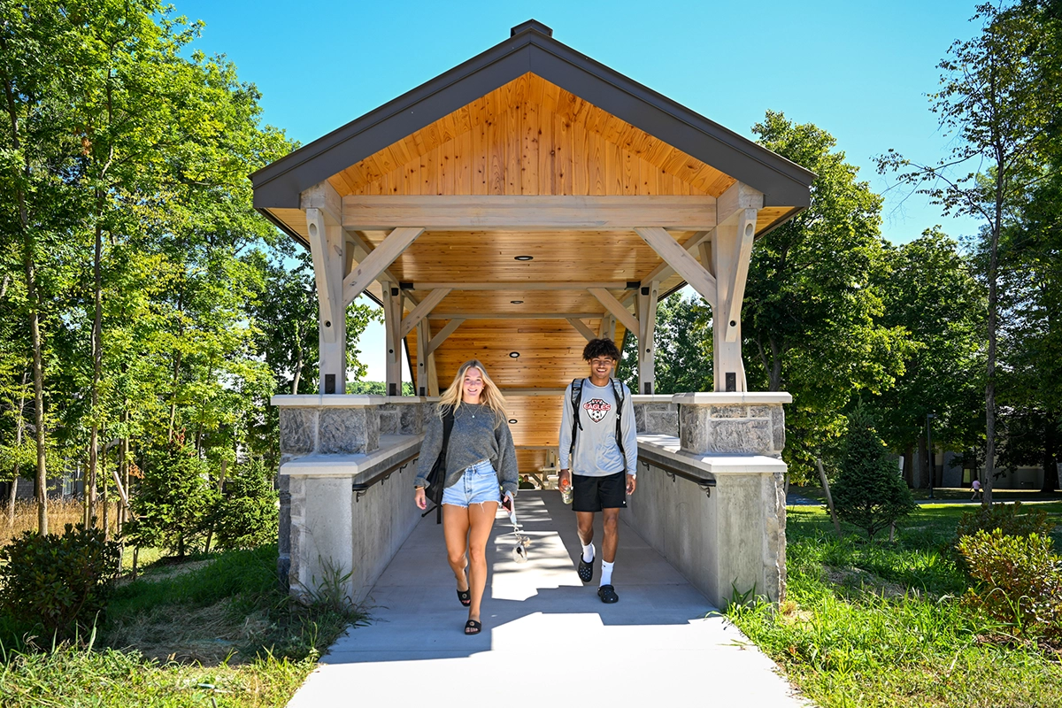 Two students walk out of the new covered staircases connecting the residence halls with academic classrooms.