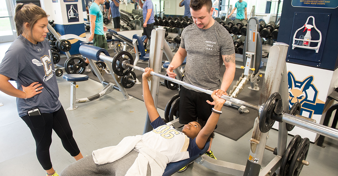 Students bench pressing in the Fitness Center