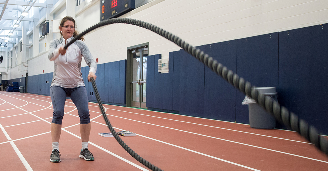 A woman uses ropes to train in the Field House