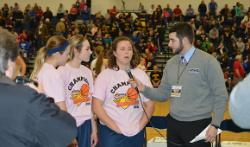 A student interviews a team during halftime.