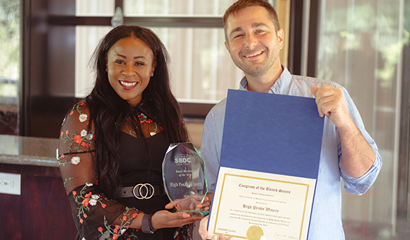 SBDC State Director Sonya Smith presents High Peaks owner Matthew Whalen with the SBDC 2023 Rural Business of the Year Award.