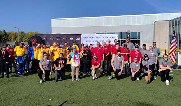 Special Olympics athletes and organizers in a group photo outside Roos House.