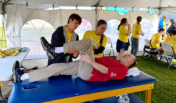 Physical Therapist Assistant students assist athletes with stretching.