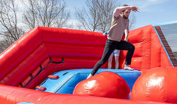 A student runs through a bounce house obstacle course during Spring Fest.