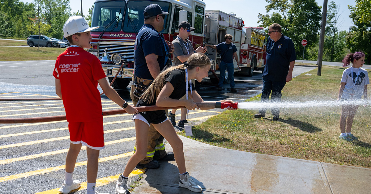 Students use a fire hose during Emergency Responder camp.