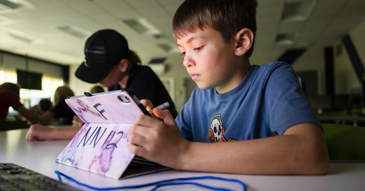 Two students use iPads to sketch digital drawings during summer camp.
