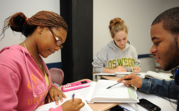 Three students study in a classroom