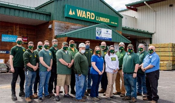 Ward Lumber employees stand outside Malone store.