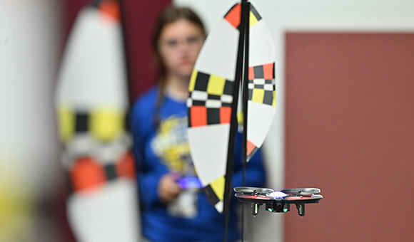 A student launches a drone during summer camp.