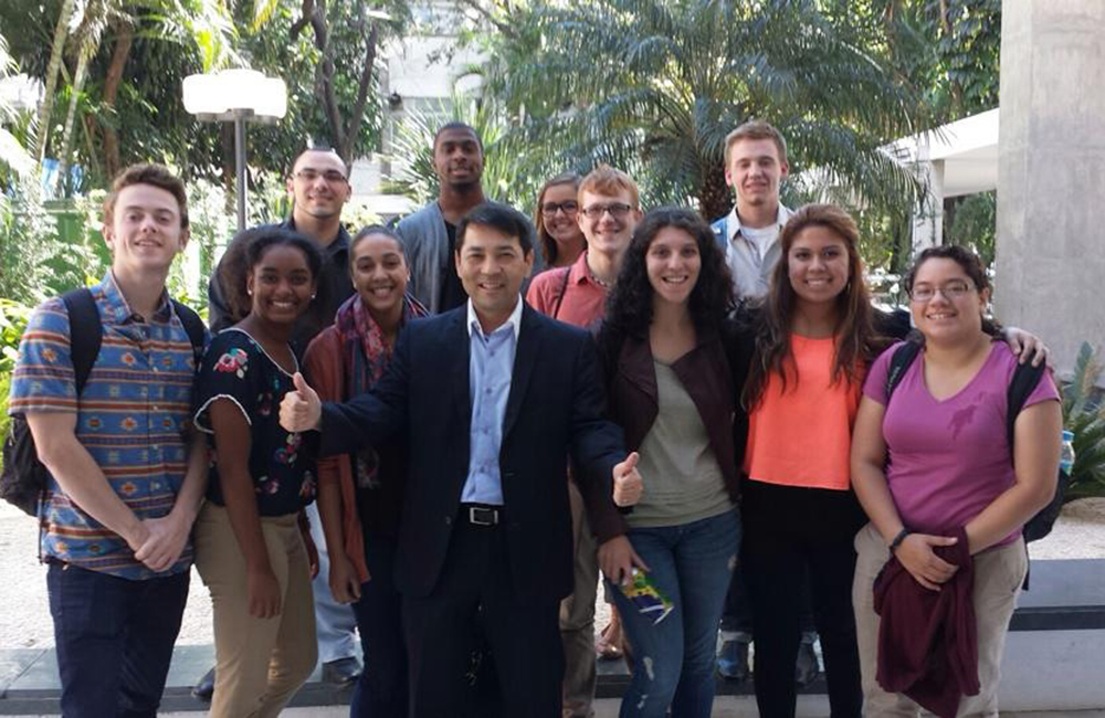 A faculty member stands with his students abroad.