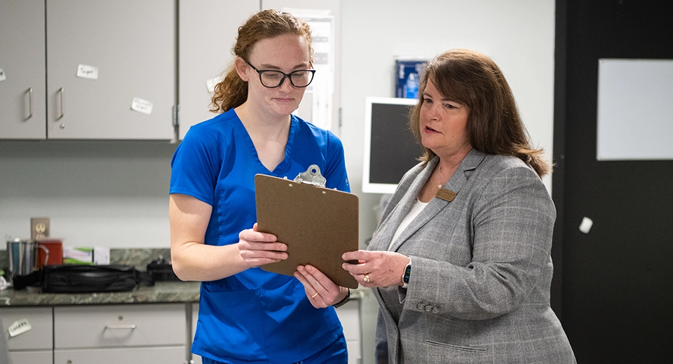 Vicki Perrine speaks with a nurse in the Nursing Simulation Lab.