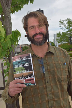 Chris Fink holds his latest book